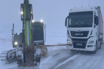 Karda nedeniyle yolda kalan TIR'a iş makineli kurtarma